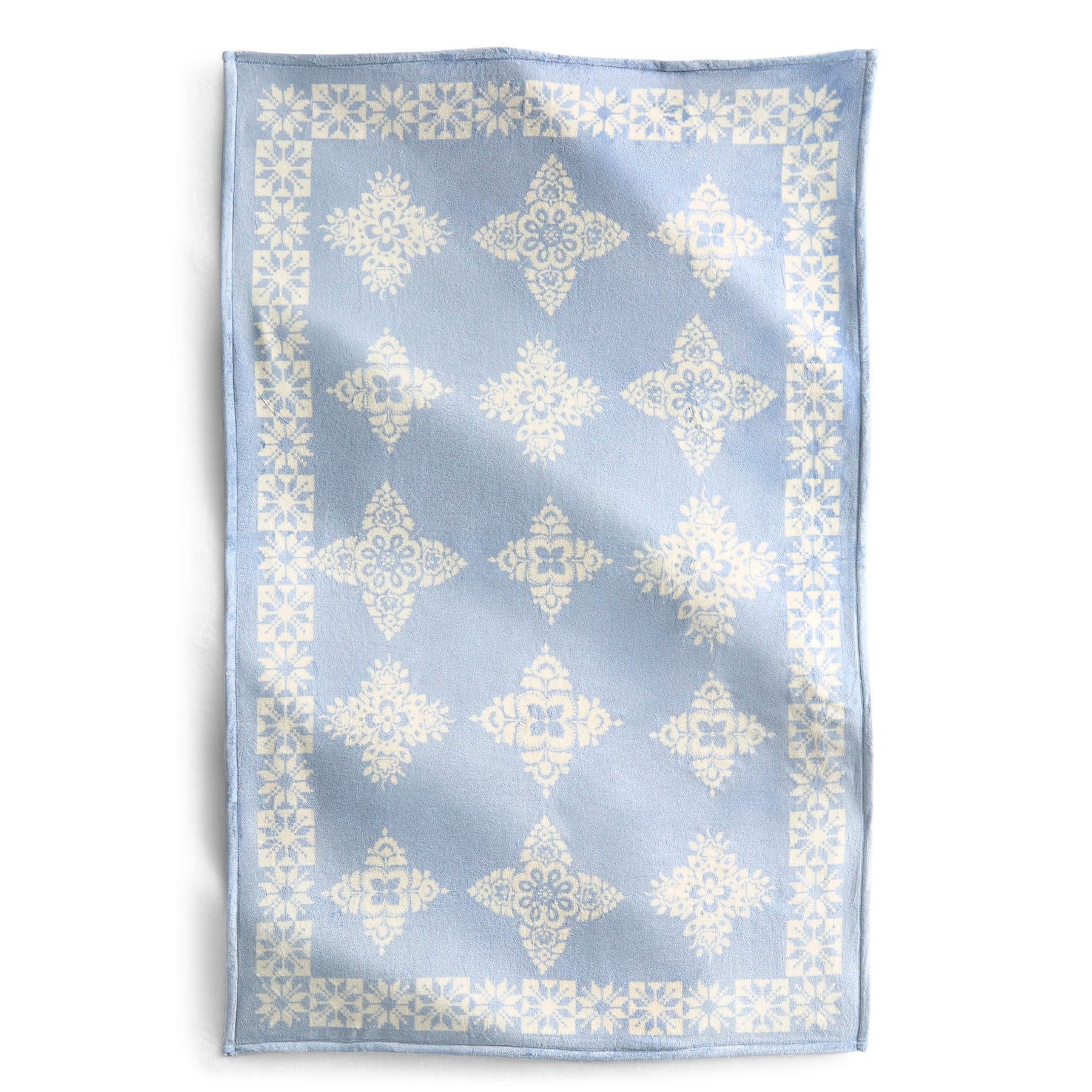 light blue throw blanket with white starry snowflake pattern
