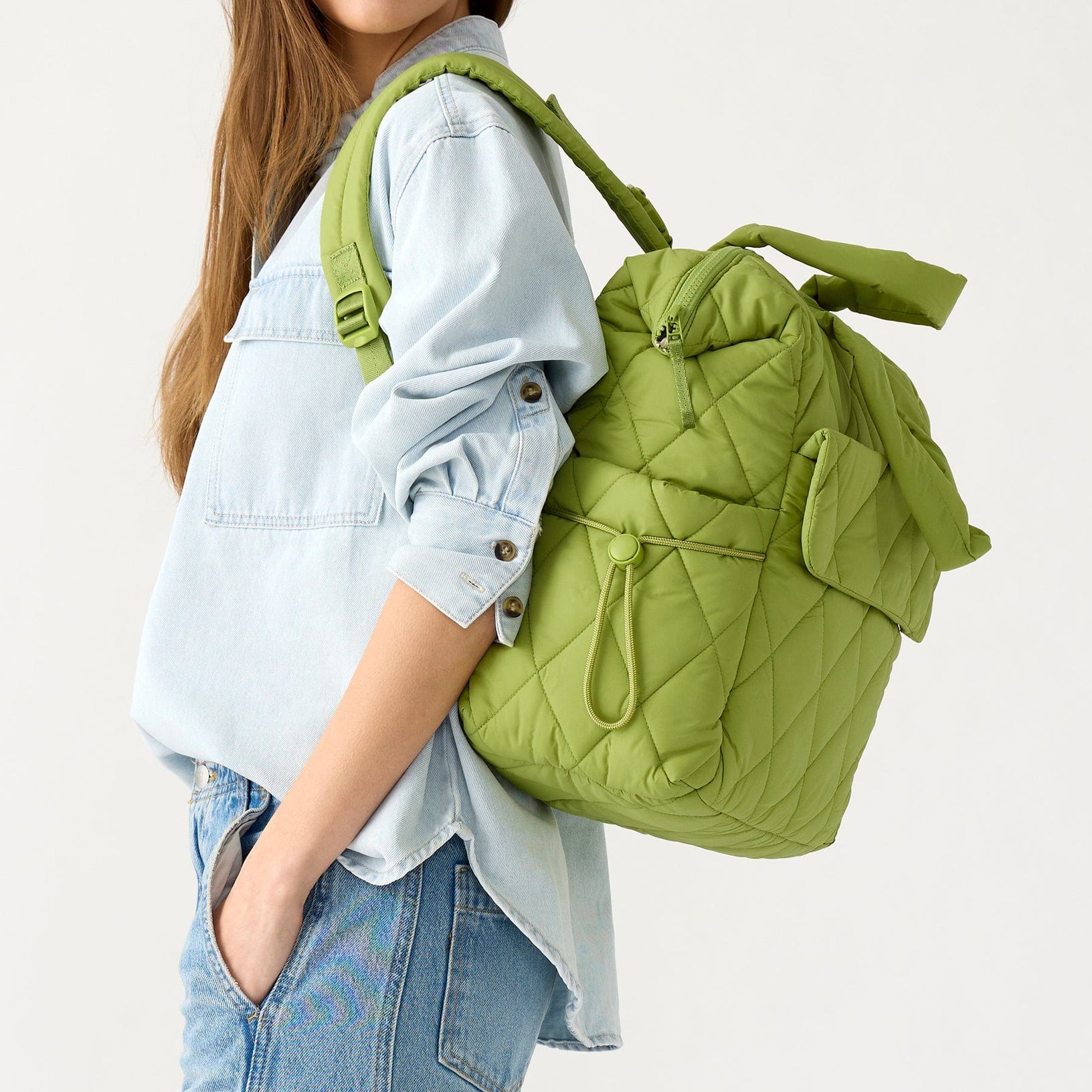 model with lightweight lime green quilted diaper bag backpack thrown over her shoulder