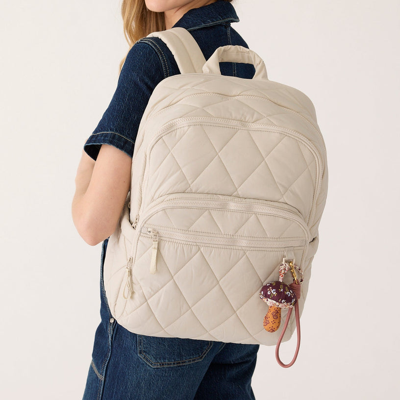 large lightweight quilted cream-colored backpack with water bottle holder